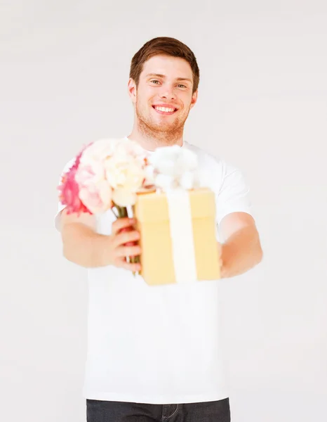 Homem segurando buquê de flores e caixa de presente — Fotografia de Stock