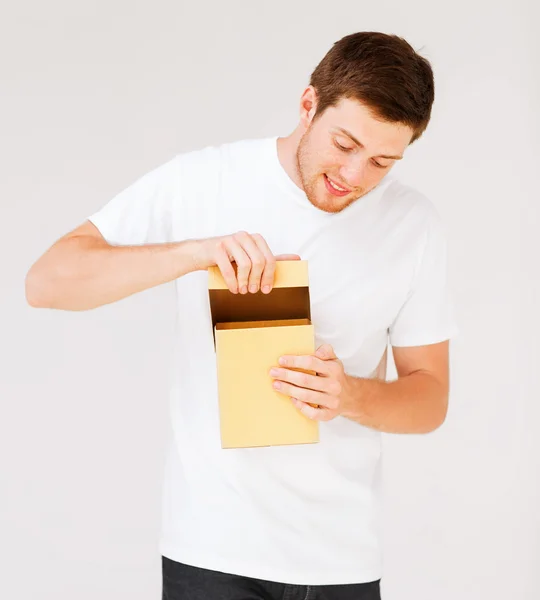 Man in het witte t-shirt met de doos van de gift — Stockfoto