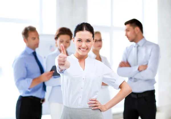 Businesswoman in office showing thumbs up — Stock Photo, Image