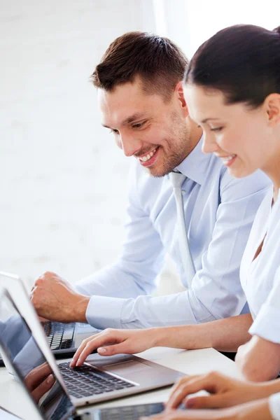 Uomo e donna che lavorano con il computer portatile in ufficio — Foto Stock