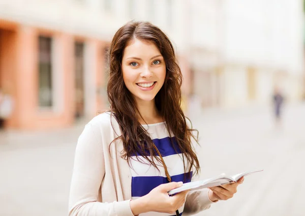 Girl looking into tourist book in the city — Stock Photo, Image