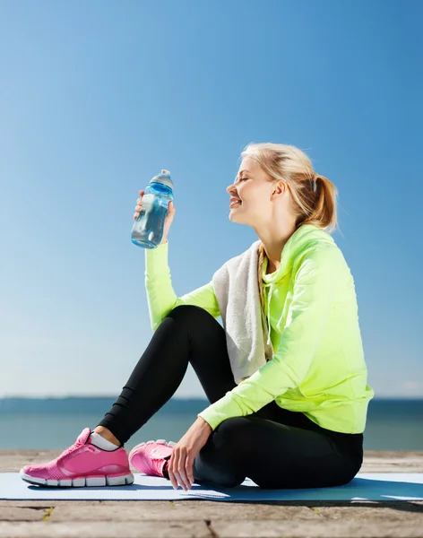 Mujer beber agua después de hacer deportes al aire libre —  Fotos de Stock