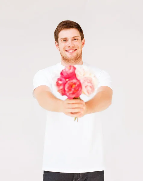 꽃의 꽃다발을 들고 젊은 남자 — 스톡 사진
