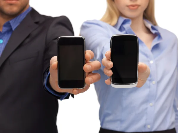 Mujer y hombre manos con teléfonos inteligentes — Foto de Stock