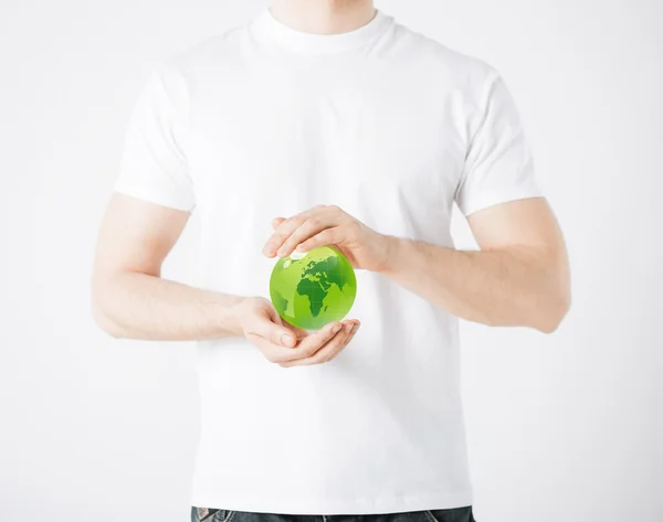 Mãos de homem segurando globo esfera verde — Fotografia de Stock