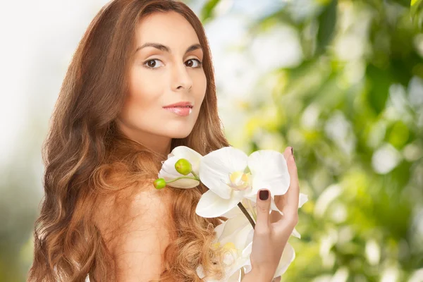 Bela mulher com flor de orquídea — Fotografia de Stock