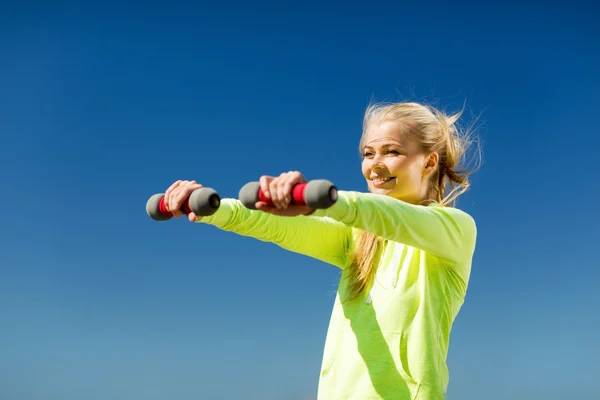 Sporty woman with light dumbbells outdoors — Stock Photo, Image