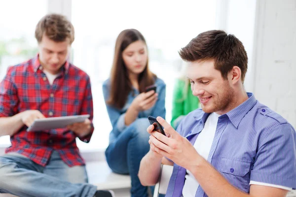 Studente in cerca di smartphone a scuola — Foto Stock