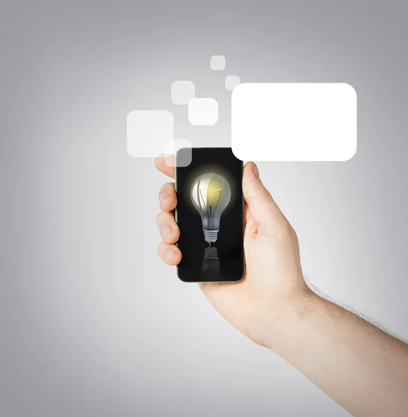 Man hand holding smartphone with light bulb — Stock Photo, Image