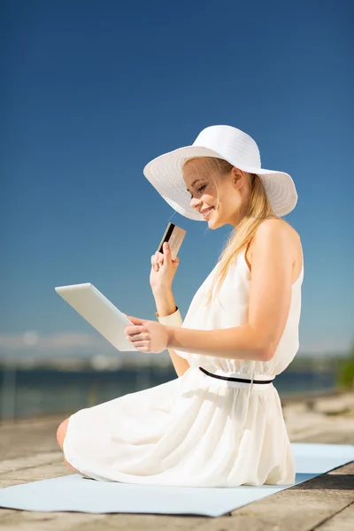 Woman in hat doing online shopping outdoors — Stock Photo, Image