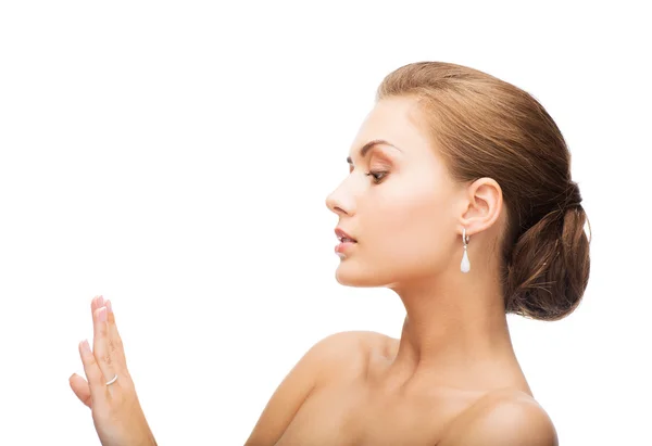 Mujer con pendientes y anillo de boda — Foto de Stock