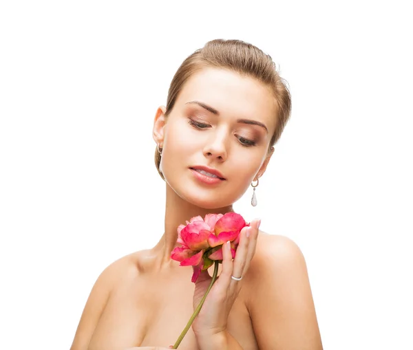 Vrouw met diamanten oorbellen, ring en bloem — Stockfoto