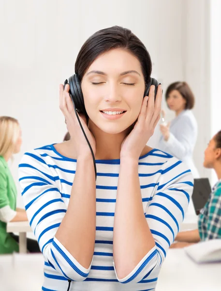 Estudiante chica en grandes auriculares en la escuela — Foto de Stock