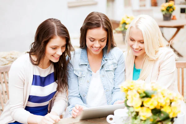 Schöne Mädchen schauen auf Tablet-PC im Café — Stockfoto