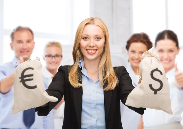 Businesswoman holding money bags with dollars — Stock Photo, Image