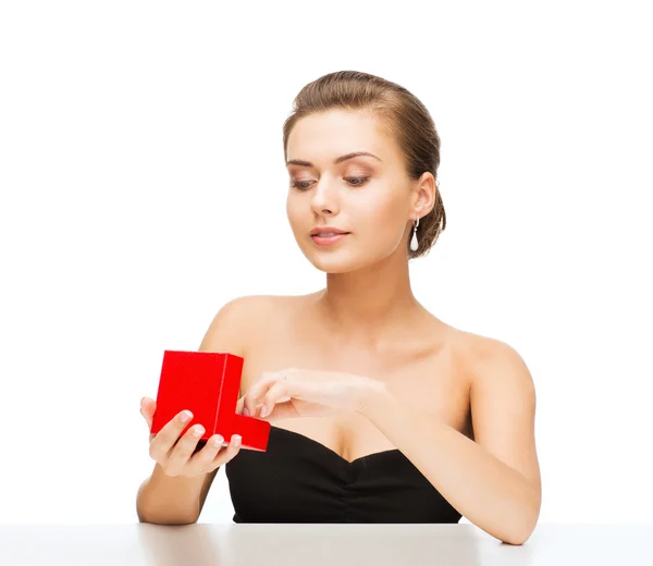 Woman with diamond earrings and gift box — Stock Photo, Image