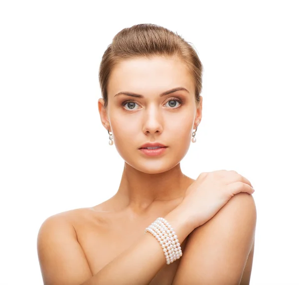 Hermosa mujer con pendientes de perlas y pulsera — Foto de Stock