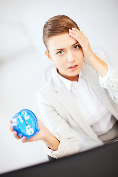 Empresária estressada segurando relógio — Fotografia de Stock