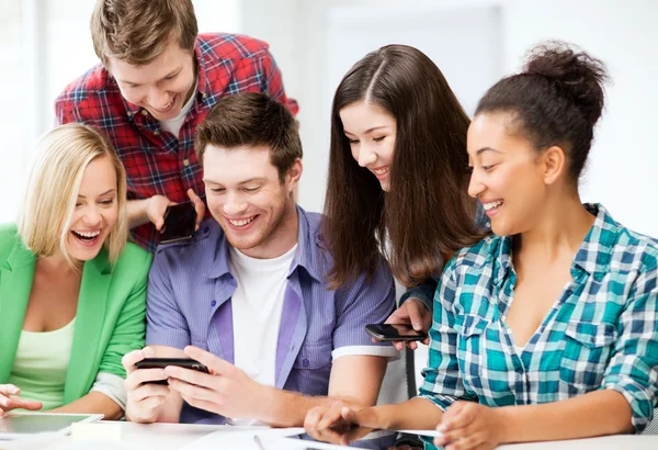 Studenti che guardano smartphone a scuola — Foto Stock