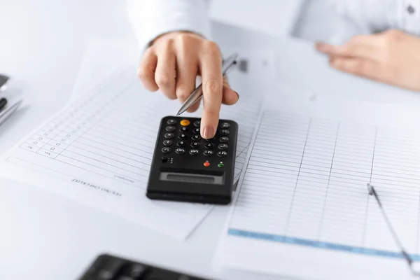 Woman hand with calculator and papers — Stock Photo, Image