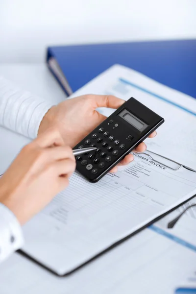 Woman hand with calculator and papers — Stock Photo, Image