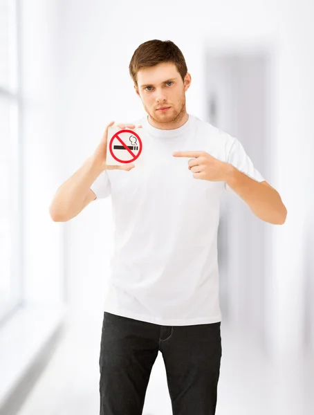 Young man pointing at no smoking sign — Stock Photo, Image