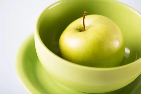 Green apple in green bowl — Stock Photo, Image