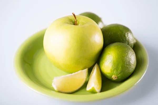 Зеленое яблоко в зеленой чаше — стоковое фото