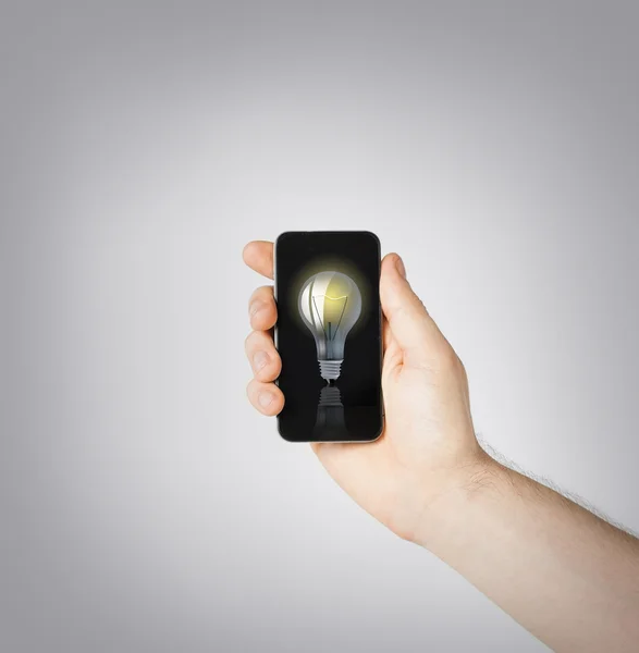 Man hand holding smartphone with light bulb — Stock Photo, Image
