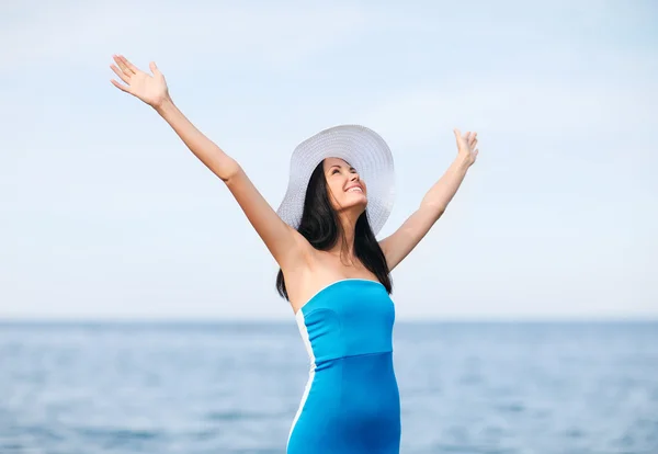 Meisje met handen omhoog op het strand — Stockfoto