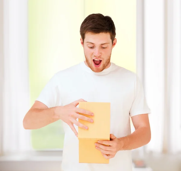 Man in white t-shirt with gift box — Stock Photo, Image
