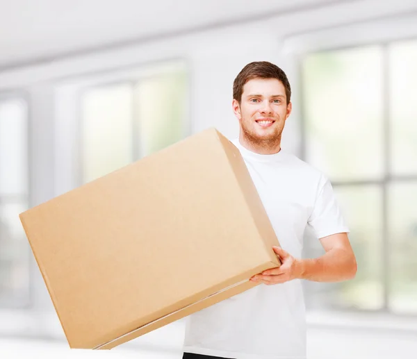 Sorrindo homem carregando caixa de papelão — Fotografia de Stock