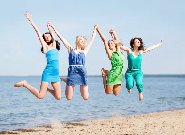 Meisjes springen op het strand — Stockfoto