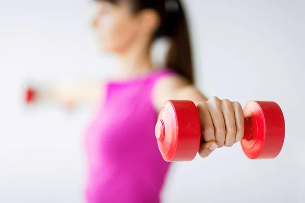 Mains de femme sportive avec haltères rouges clairs — Photo