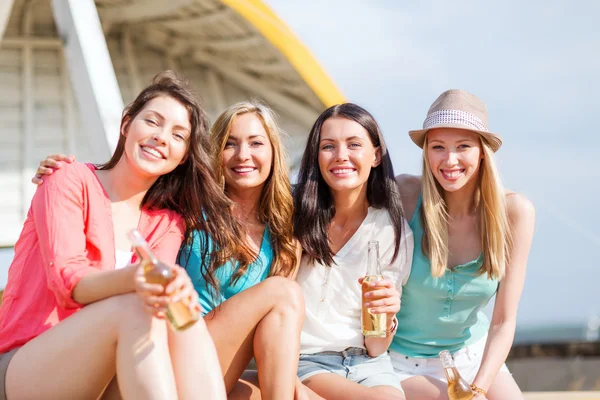 Meisjes met dranken op het strand — Stockfoto