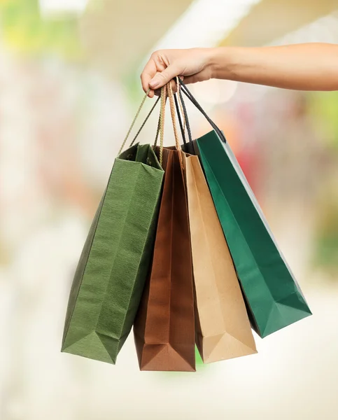 Mulheres mãos segurando sacos de compras — Fotografia de Stock