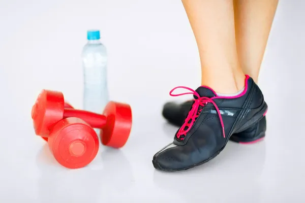 Sportovní žena nohy světle červené činky — Stock fotografie