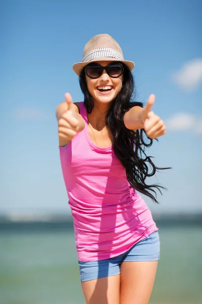 Girl showing thumbs up on the beach — Stock Photo, Image
