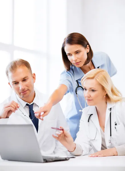 Lekarze patrząc na laptopa na spotkanie — Zdjęcie stockowe