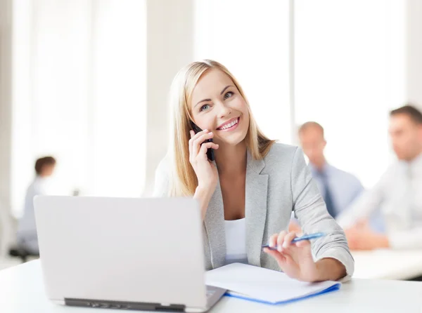 Donna d'affari con telefono in ufficio Foto Stock