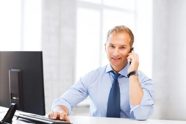 Empresário sorridente com smartphone no escritório — Fotografia de Stock