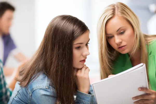 Schülerin schaut in der Schule auf Notizbuch — Stockfoto