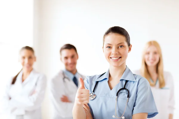 Médico com grupo de médicos mostrando polegares para cima — Fotografia de Stock