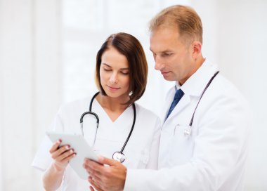 Two doctors looking at tablet pc clipart