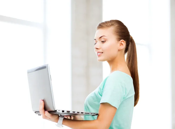 Ragazza sorridente studente con computer portatile a scuola — Foto Stock