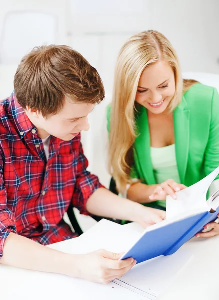 Leende studenter läser bok i skolan — Stockfoto