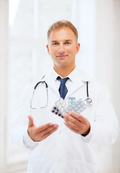 Joven médico masculino con paquetes de pastillas —  Fotos de Stock