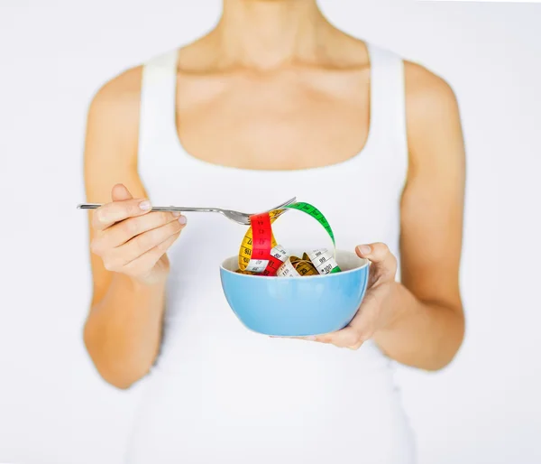 Kvinna händer som håller skål med måttband — Stockfoto