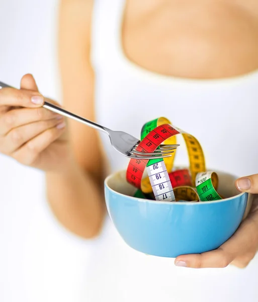 Woman hands holding bowl with measuring tape — Stock Photo, Image