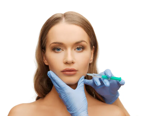 Woman face and beautician hands with syringe — Stock Photo, Image